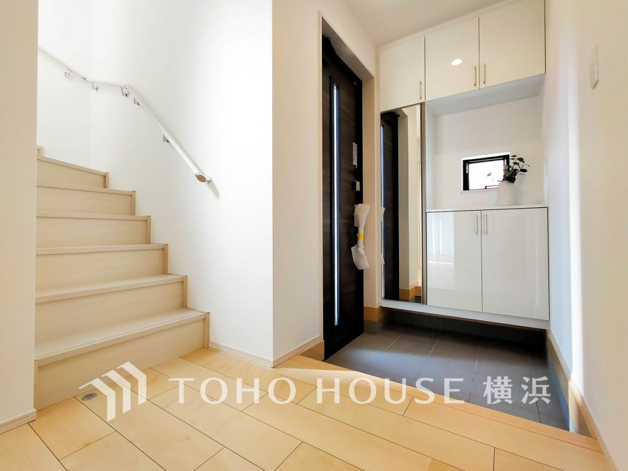 豊富な収納を確保した玄関スペース。便利な大型のミラーのついたシューズボックスを設置。
