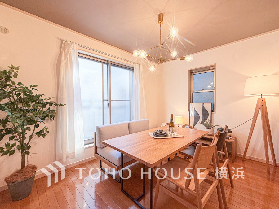 木の温もりを感じるダイニング。大きな窓から自然光が入り、落ち着いた照明が心地よい空間を演出します。