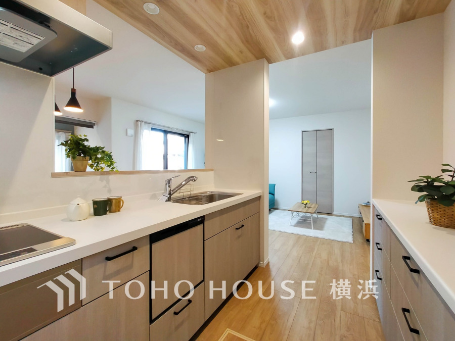 あたたかな木目天井と明るい色調、カップボードも備えた機能的なキッチン。リビングとつながり、家族の会話が弾む開放的な空間です。