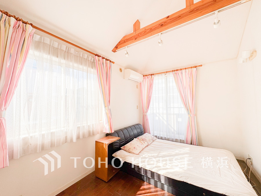 柔らかな光が差し込む明るい洋室。木の梁がアクセントとなり、温かみのある空間を演出しています。