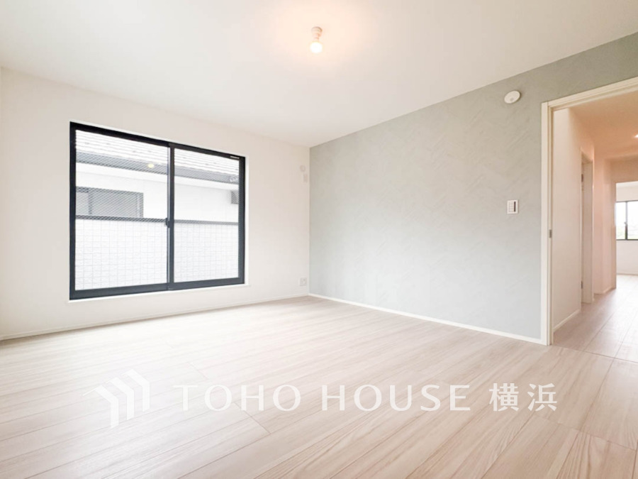 ナチュラルな色合いと大きな窓で明るく開放的なリビングルーム。シンプルで使いやすい空間設計です。