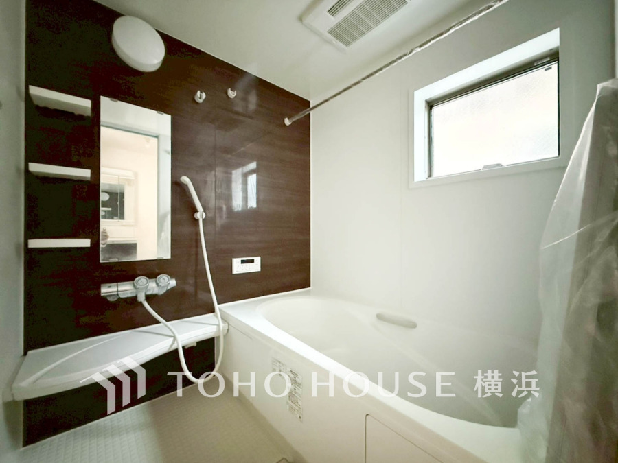 清潔感あふれるバスルームは、ブラウンのアクセント壁が落ち着きを演出し、快適なバスタイムを実現します。