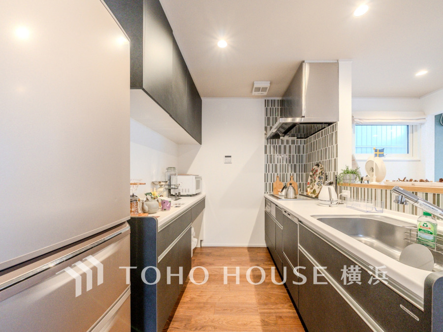 収納棚を背面に設置した統一感のあるキッチンスペースは美しく、機能性も良好です。
