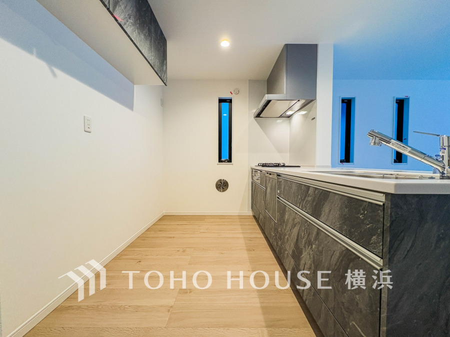 スタイリッシュな石目調のキッチンは収納豊富で、明るい窓から自然光が差し込む快適な調理空間です。