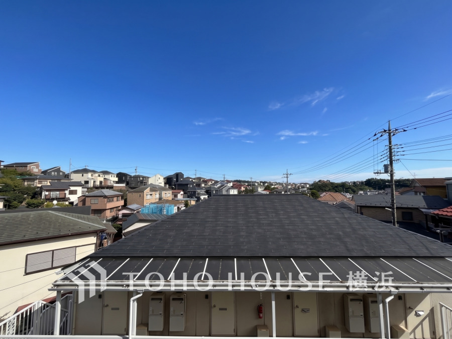 青空が広がる閑静な住宅街の風景。周囲に高い建物がなく、開放的な眺望が魅力です。