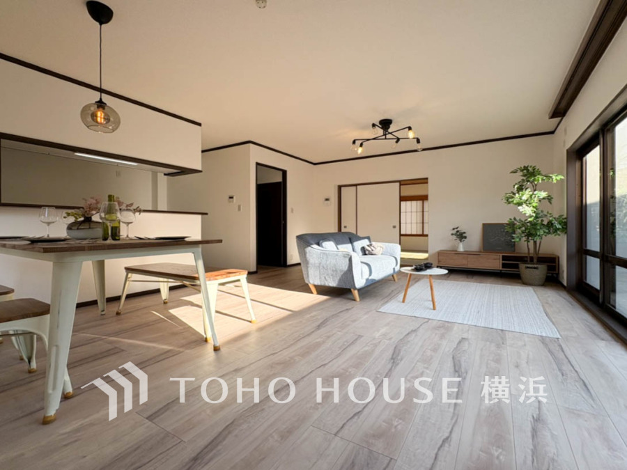 明るい陽射しが差し込む広々としたリビング。ナチュラルな木目床とシンプルな家具が調和した快適空間です。