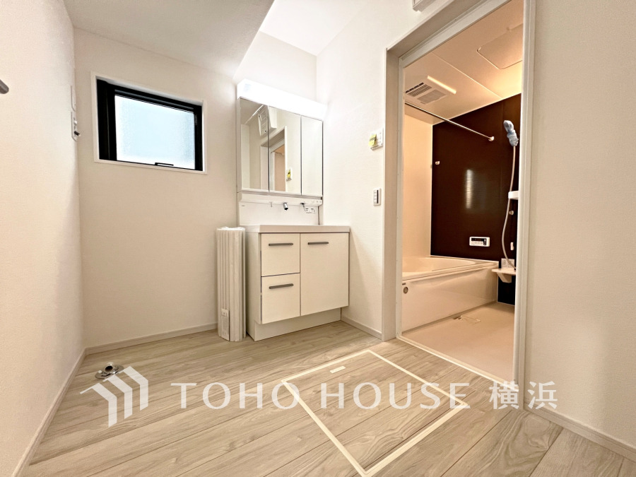 清潔感あふれる洗面室と浴室。明るい窓からの自然光で快適な空間を実現しています。