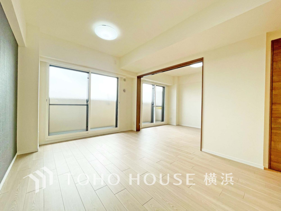 大きな窓から自然光が差し込む明るいリビング。隣接する部屋とつなげて広々使える設計です。