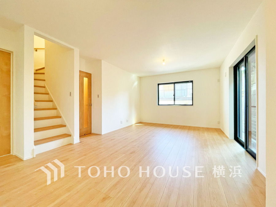 明るい光が差し込む広々としたリビング。ナチュラルな木目調フローリングで温かみのある空間です。