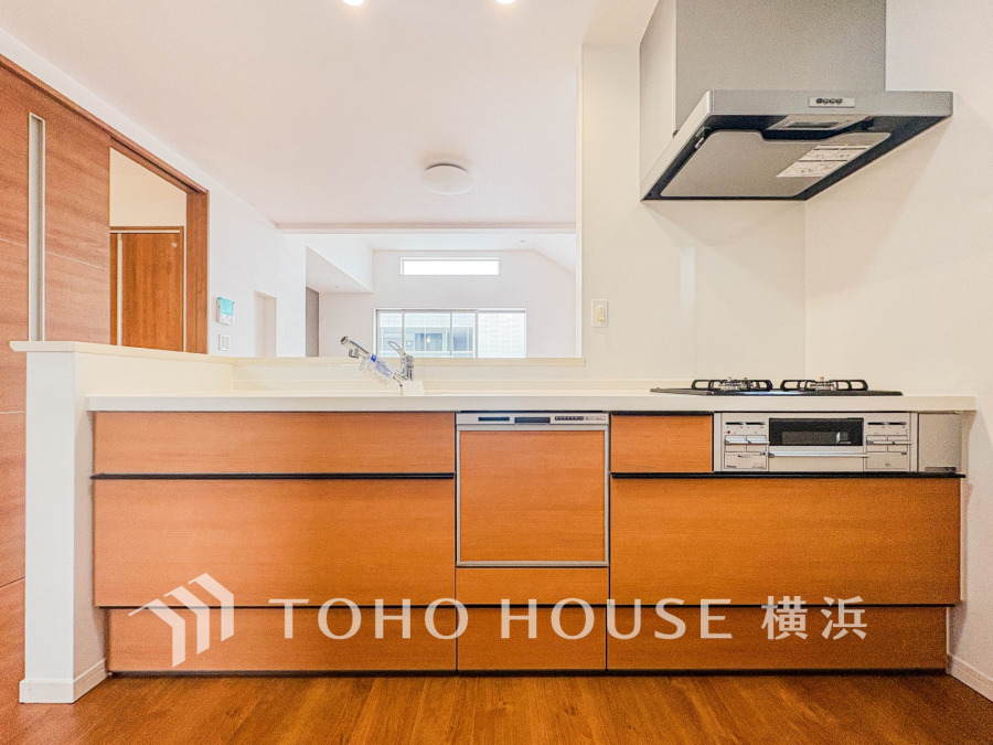 木目調の収納が美しい対面キッチン。開放感あるリビングとつながり、家族との会話も弾みます。