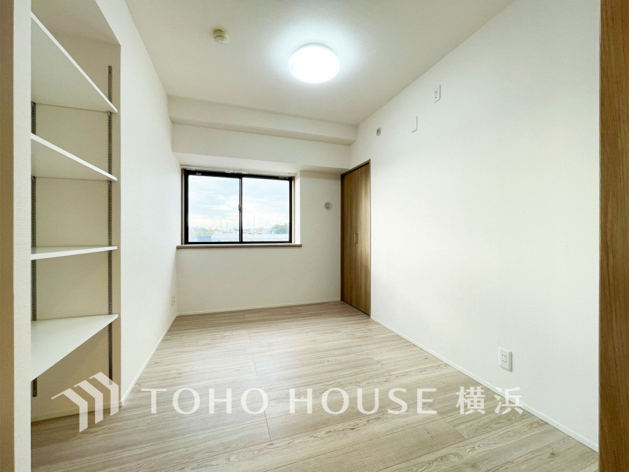 清潔感あふれるホワイト基調の洋室。窓からの自然光が心地よく、収納も充実した快適な空間です。