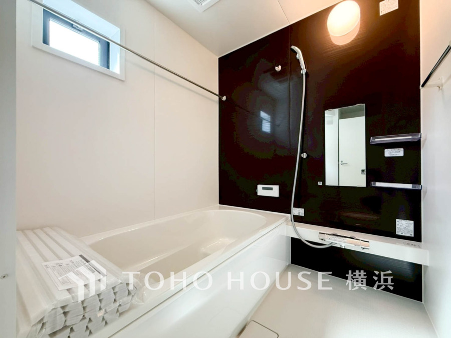 シンプルで清潔感のあるバスルーム。黒の壁面がアクセントとなり、落ち着いた空間を演出しています。