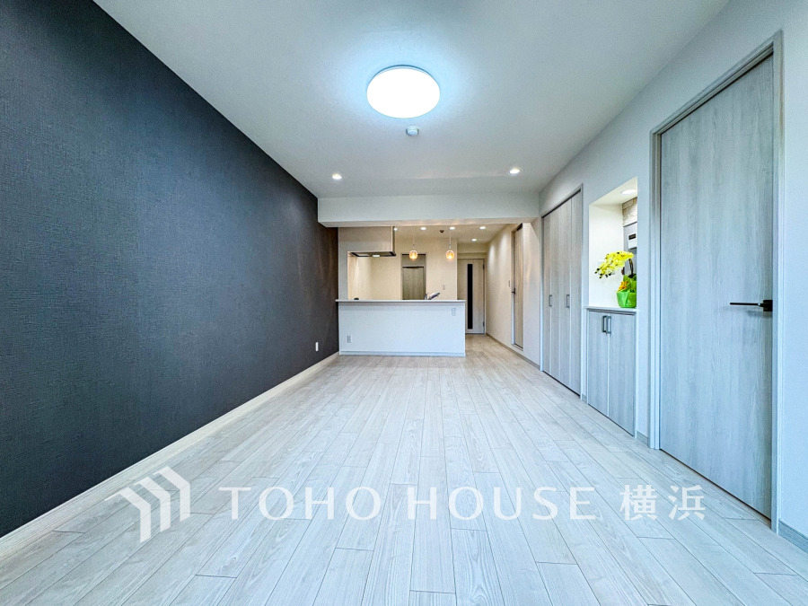 シンプルでモダンなデザインのリビング。明るい床とアクセントクロスが調和し、開放感あふれる空間を演出します。