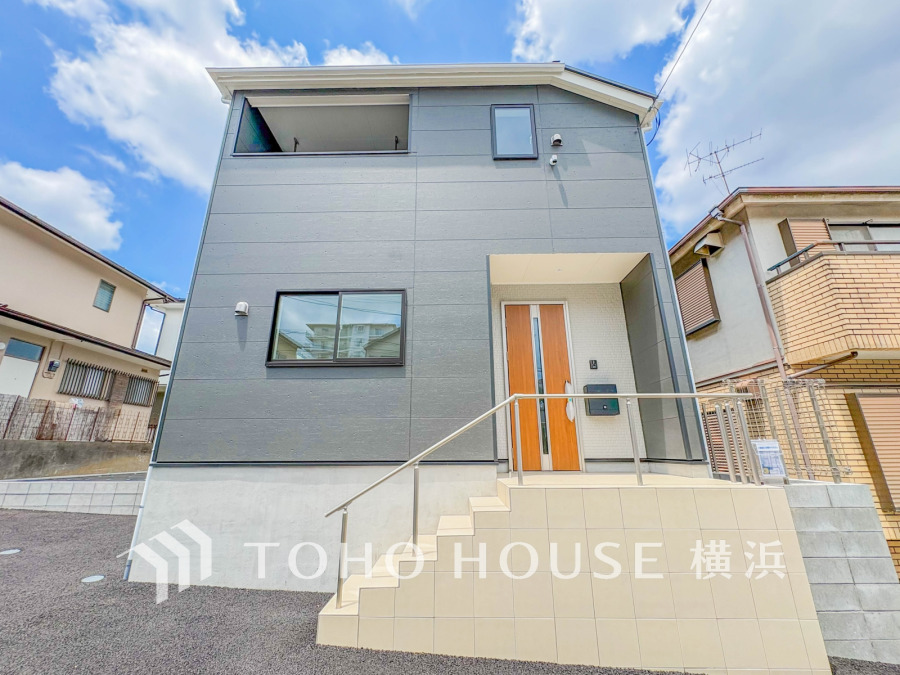 閑静な街並みに調和する落ち着いた外観。ふりそそぐ陽射しと青空を背景に美しさを醸す佇まい。
