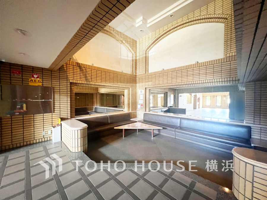 大きな窓と高い天井が印象的なホテルライクのエントランスロビー
