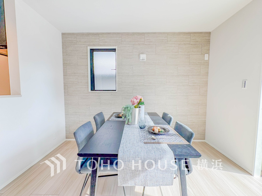 シンプルで明るいダイニングは、家族の団らんに最適な落ち着いた空間。壁のアクセントが上質感を演出します。