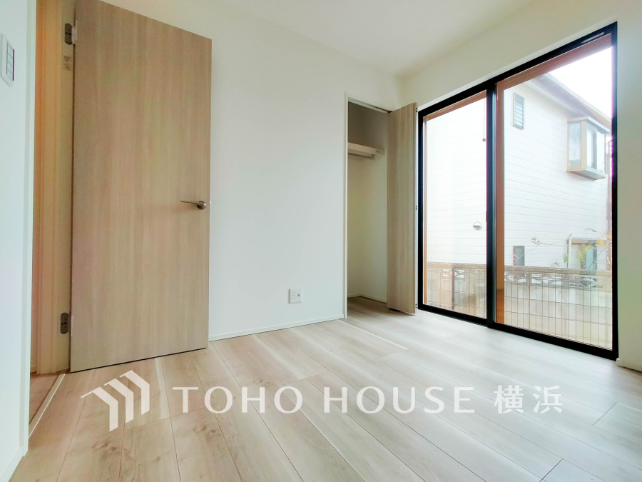 大きな窓から自然光が差し込む明るい洋室。収納付きで快適な住空間を実現しています。