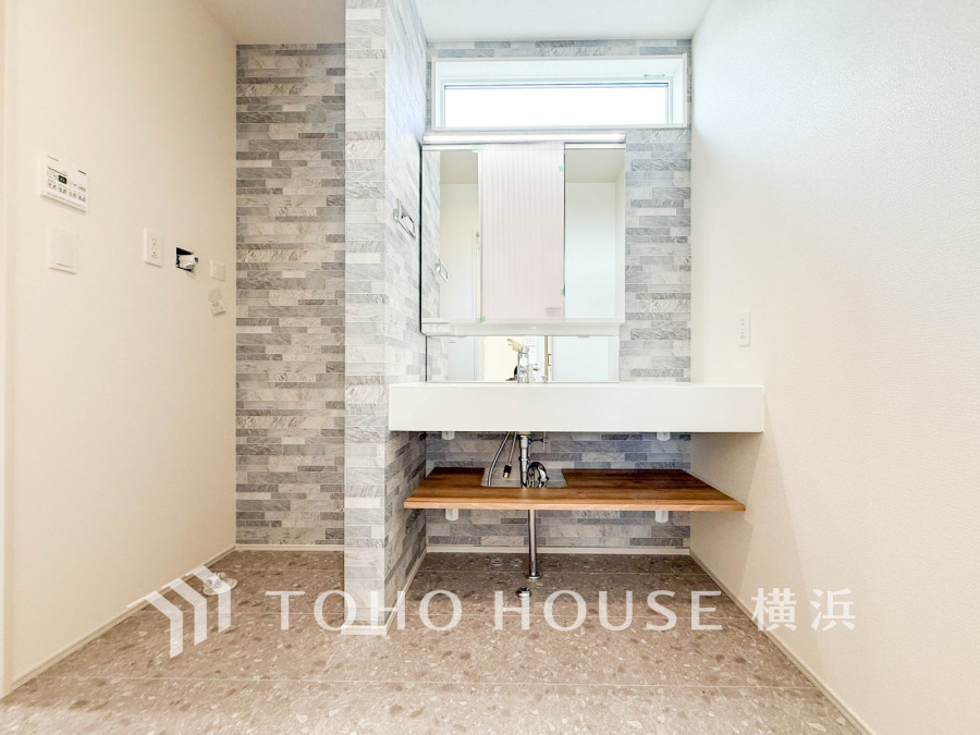 洗面空間は壁のタイルがアクセントとなり、清潔感と高級感を演出しています。