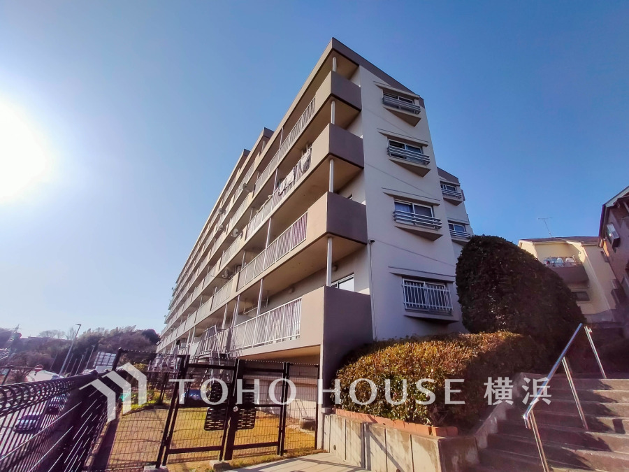 陽当たり良好な6階建てマンション。緑豊かな植栽と共に、穏やかな住環境を提供します。