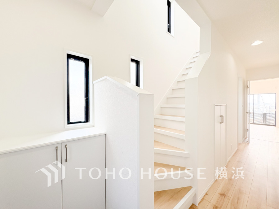 白を基調とした明るく開放的な玄関・階段ホール。窓からの自然光が心地よい空間を演出しています。