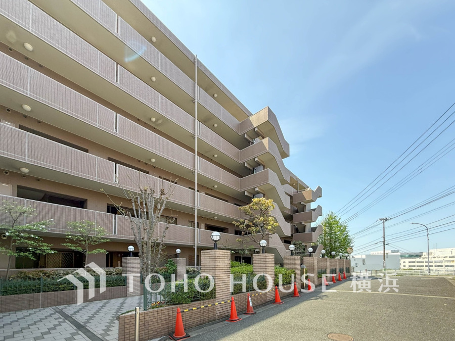 落ち着いた外観のマンション。広々とした敷地と緑豊かな植栽が心地よい住環境を演出しています。