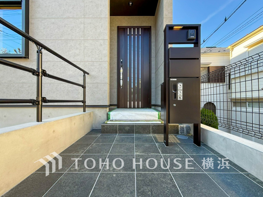 スタイリッシュな玄関アプローチはタイル仕上げで清潔感があり、宅配ボックス付きで便利な設計です。