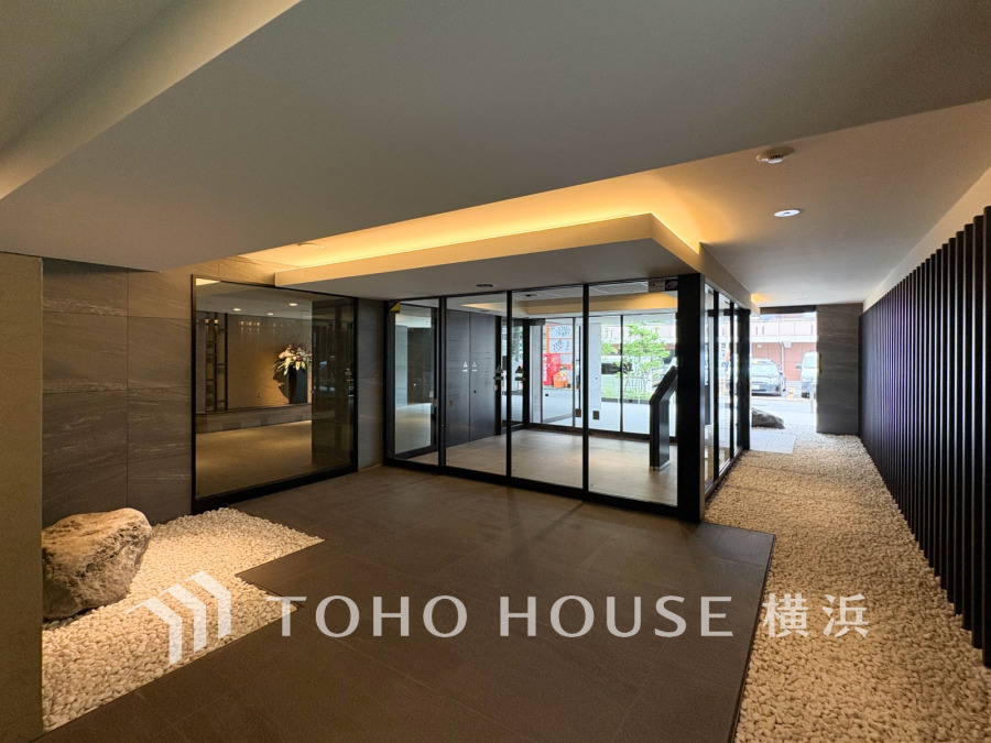 上質感溢れる落ち着いた照明と石畳が調和する、洗練されたマンションのエントランスホール。