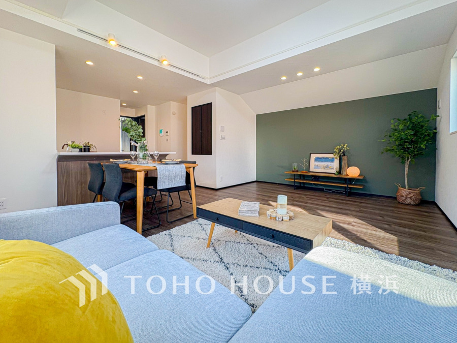 自然光が差し込む広々リビング、落ち着いたアクセントクロスと木目調の家具が調和した快適空間です。