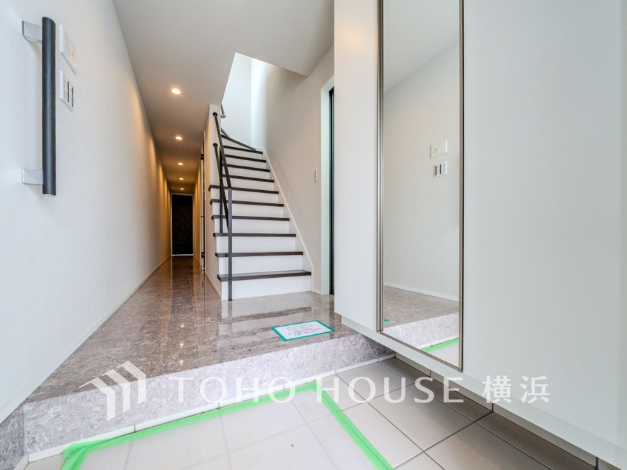 自然光が差し込む明るい玄関。便利な大型のミラーのついたシューズボックスを設置しています。