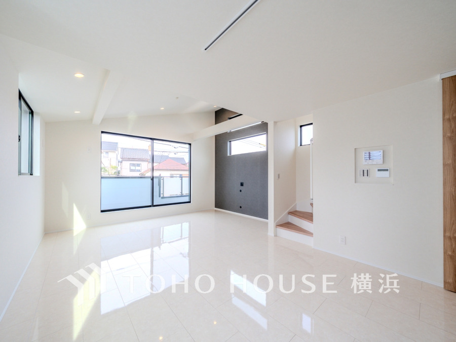 自然光がたっぷり入る明るいリビング。白を基調とした清潔感ある空間で、家族の団らんに最適です。