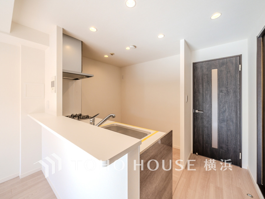 シンプルで清潔感溢れる対面キッチン。使いやすさと開放感を両立した快適な空間設計です。