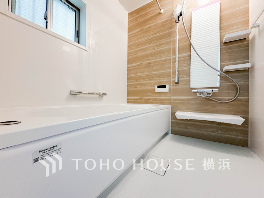 木目調パネルが温かみを演出する、清潔感あふれるシンプルなバスルームです。快適な入浴時間を提供します。