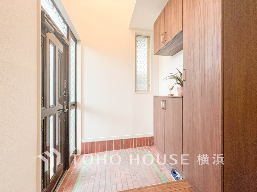 明るい窓から自然光が差し込む、収納充実の玄関スペースです。