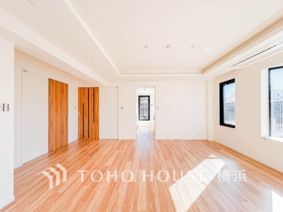 明るい自然光が差し込む広々としたリビングは、木目調のフローリングが温かみを演出する快適空間です。