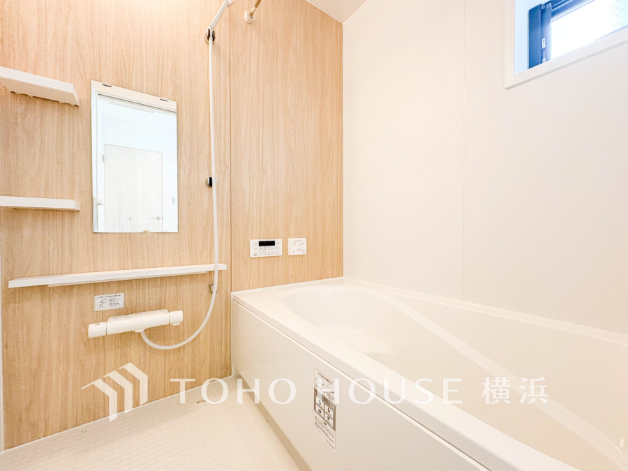 木目調の壁が温かみを演出する、清潔感あふれるバスルーム。ゆったりくつろげる浴槽が魅力です。