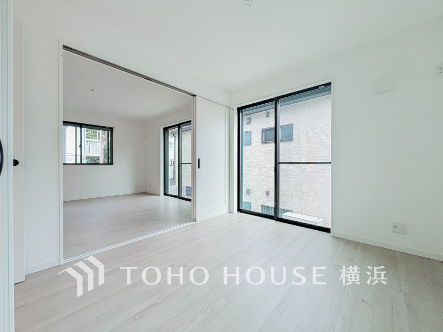 大きな窓から自然光が差し込む明るい室内。スライドドアで空間の使い分けが可能な快適な居住空間です。