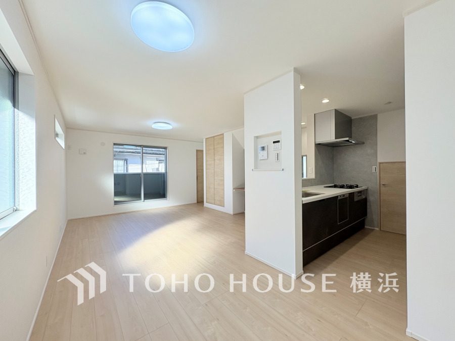 明るい自然光が差し込む、開放感あふれるリビングと機能的な対面キッチンの快適空間です。