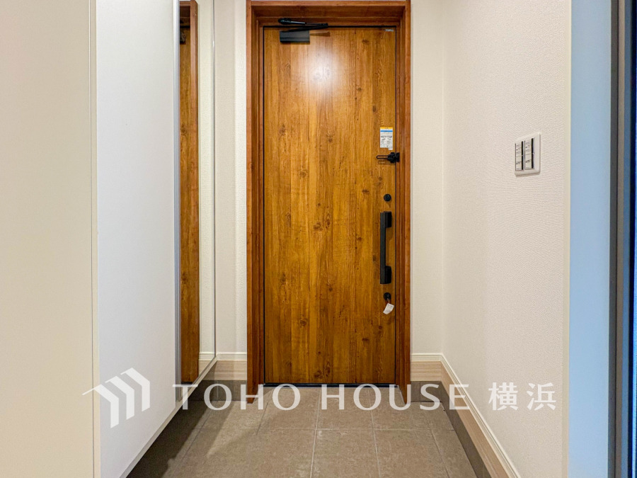 木目調の玄関ドアが温かみを演出。シンプルで清潔感あふれる玄関スペースです。