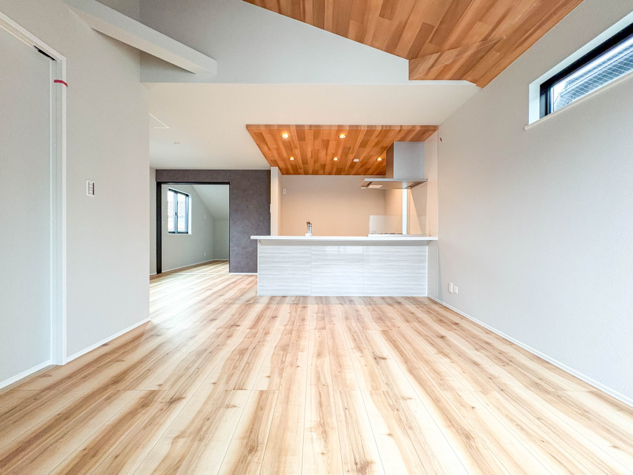 木目調の天井と床が調和する明るく開放的なリビングキッチン。家族団らんに最適な快適空間です。