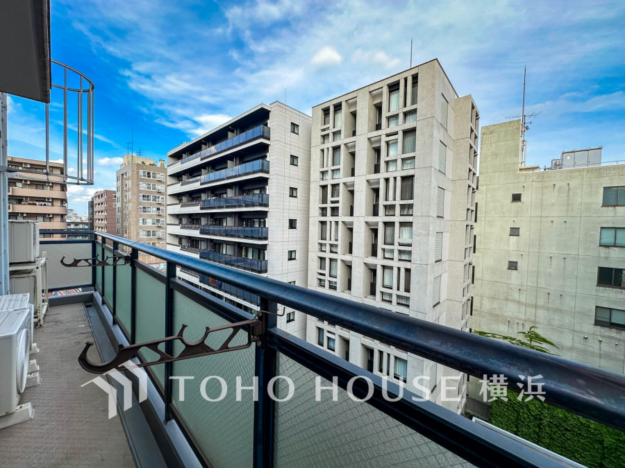 開放感あるバルコニーからの眺望。周囲に高層建物が立ち並ぶ都市型マンションの快適な屋外スペースです。