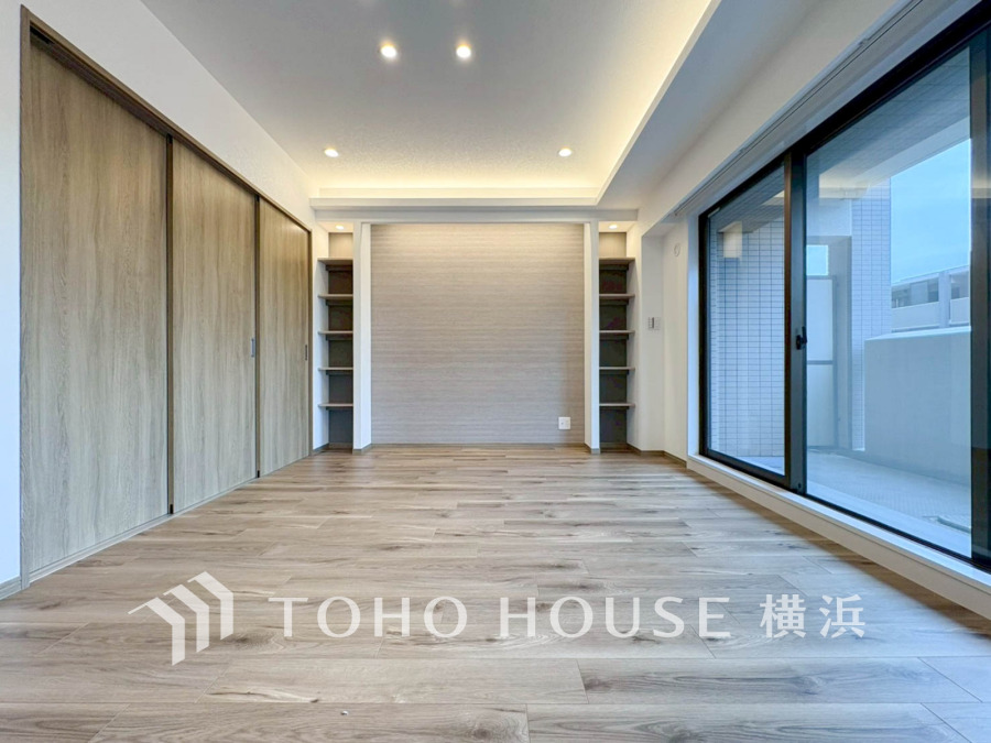 大きな窓から自然光が差し込む、開放感あふれるモダンなリビングルームです。収納も充実しています。