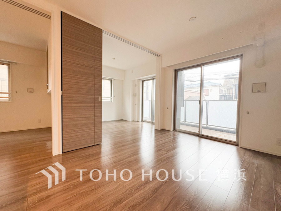 大きな窓から光が差し込む明るいリビング。可動式の扉で空間の使い分けも自在です。