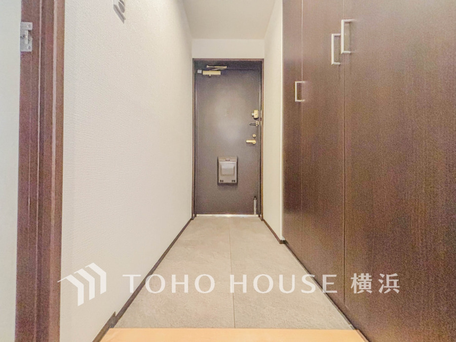 シンプルで清潔感のある玄関。壁一面の収納で靴や小物をすっきり収納可能です。
