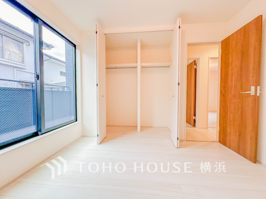 大きな窓から自然光が差し込む明るい洋室。収納力のあるクローゼット付きで快適な住空間を実現しています。