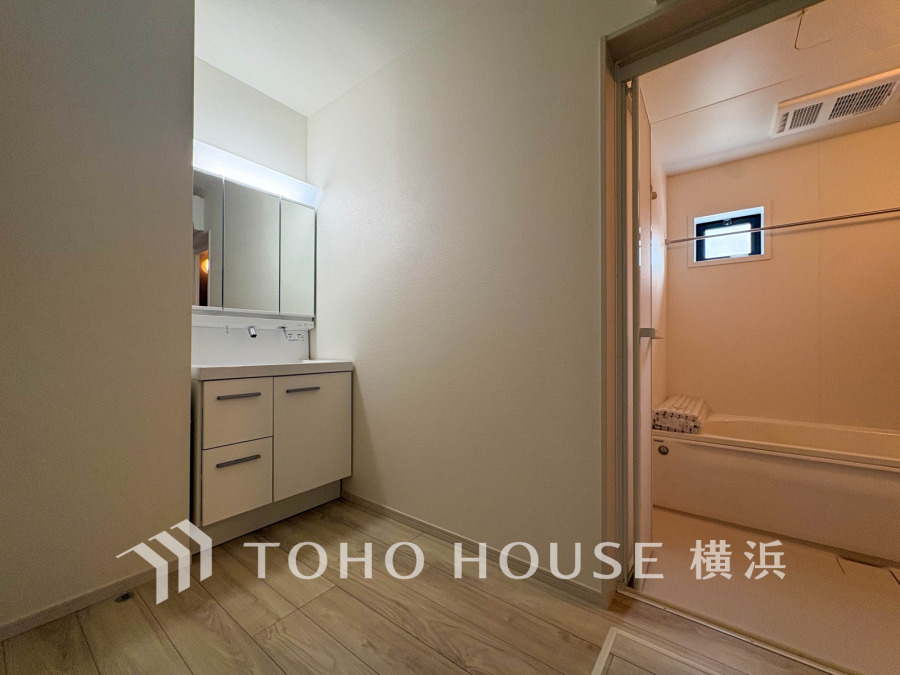 清潔感あふれる洗面スペースとバスルーム。収納力のある洗面台で使い勝手も良好です。ゆったりとした空間設計が魅力。