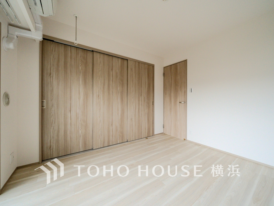 ナチュラルな木目調の収納扉が調和する明るく広々とした洋室。快適な住空間を実現します。