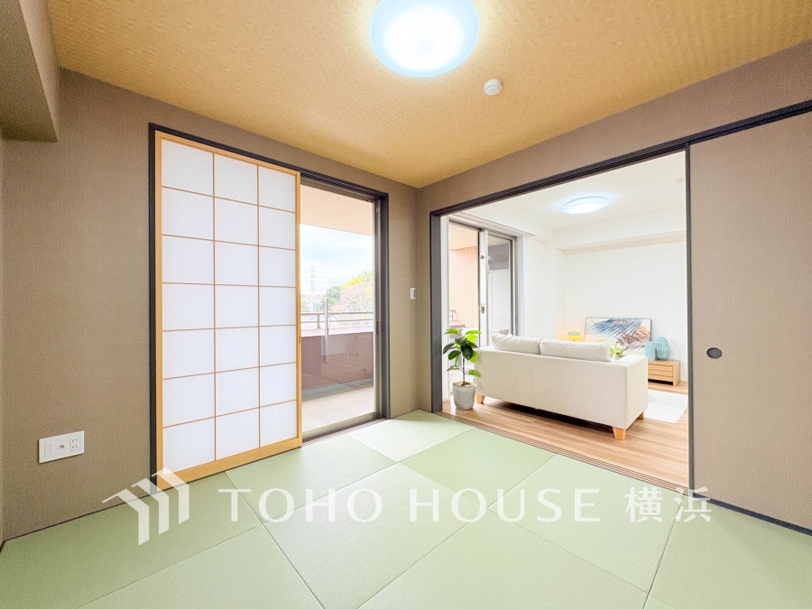 自然光が差し込む和室とリビングが続く開放的な空間。障子戸で落ち着いた雰囲気を演出します。