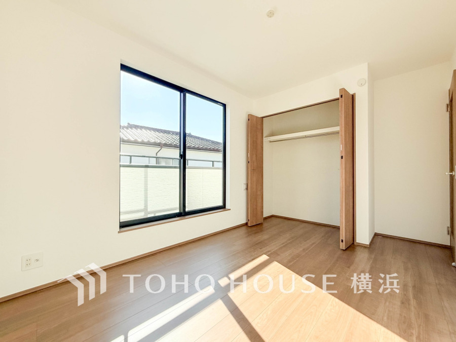 バルコニーから明るい自然光が差し込む洋室。大型クローゼット付きで収納も充実しています。
