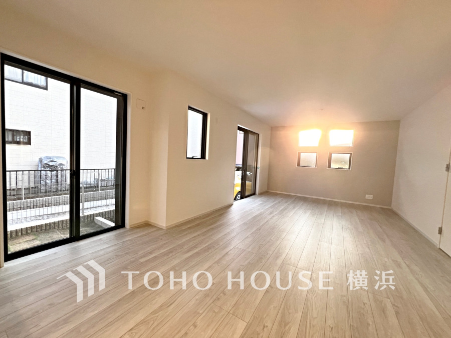 陽光が差し込む広々としたリビング。大きな窓で開放感があり、明るく快適な空間です。