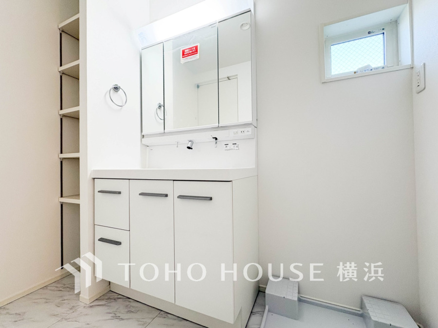清潔感あふれる白を基調とした洗面室。収納スペースも充実し、使い勝手の良い設計です。
